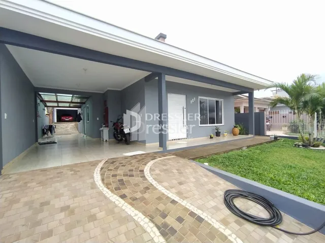 Fachada de uma casa moderna em Lajeado, Brasil, com área coberta e piso de tijolos.