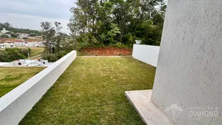 Vista de um terreno gramado delimitado por muros brancos.