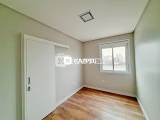 Foto de um cômodo interno com paredes claras e piso de madeira.