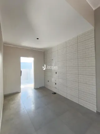 Corredor interno com paredes brancas e piso de cerâmica.