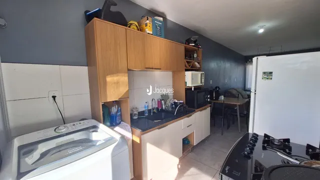 Foto de uma cozinha com armários de madeira e bancada escura.