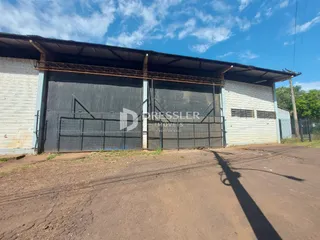 Fachada de um galpão industrial com portas de garagem metálicas.