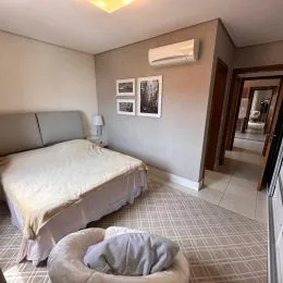 Quarto com cama de casal e paredes claras.