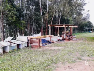 Fachada de uma propriedade com estruturas de madeira no quintal.