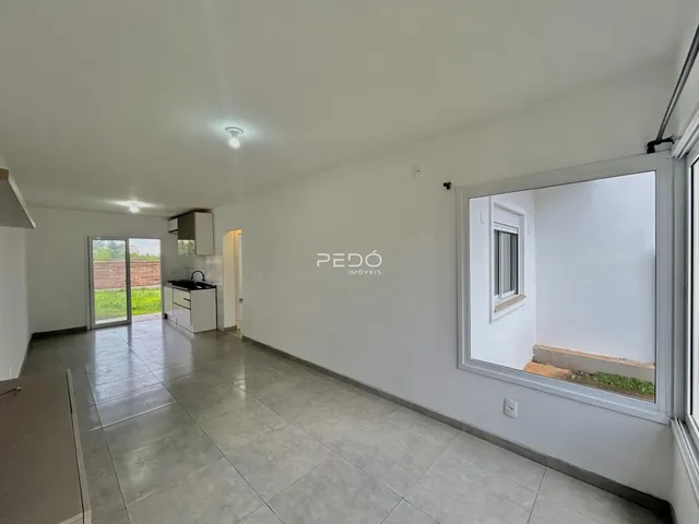 Vista interna de uma sala com piso de cerâmica e paredes brancas.