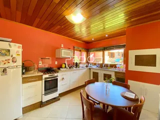 Foto de uma cozinha com armários brancos e teto de madeira.