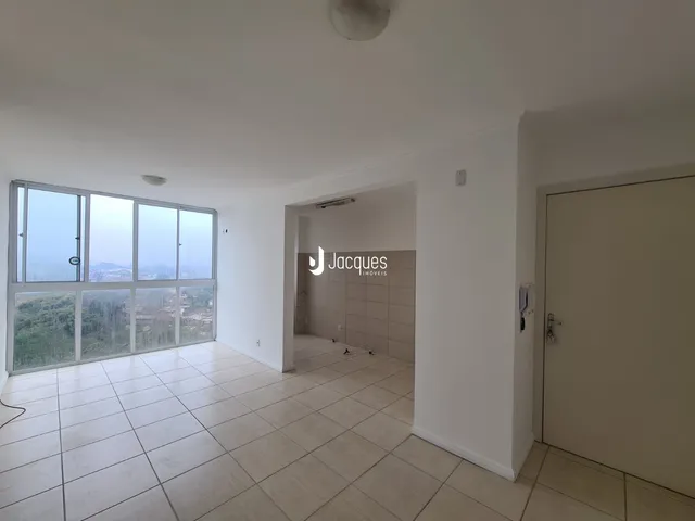 Sala ampla com grande janela e vista para a paisagem.