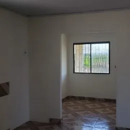 Foto de um corredor interno com paredes brancas e piso de cerâmica.