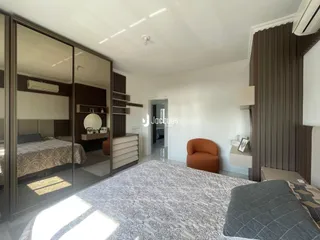 Quarto com paredes de madeira e espelho refletindo o ambiente.