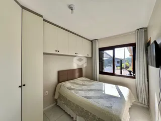 Quarto com armários embutidos e janela de madeira.