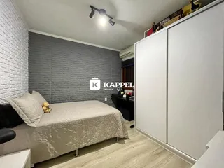 Quarto com cama e armário branco em um apartamento.