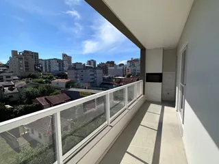 Vista externa de um terraço com grade de vidro mostrando o horizonte.