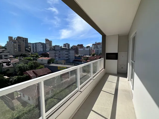 Vista externa de um terraço com grade de vidro mostrando o horizonte.