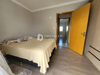 Quarto com cama e paredes claras em um imóvel no Brasil.