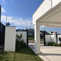 Fachada de uma residência com parede branca e área coberta em Lajeado, Brasil.