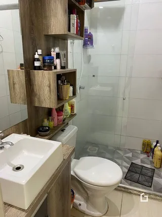 Foto de um banheiro com revestimento cerâmico branco.