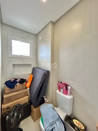 Foto de um corredor interno com um vaso sanitário e caixas de armazenamento.