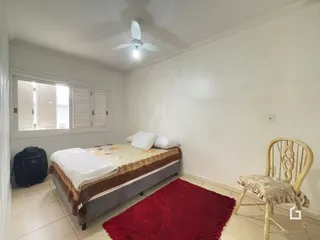 Quarto com cama e janela em uma residência.