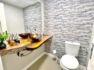 Foto de um banheiro com revestimento de pedra na parede.
