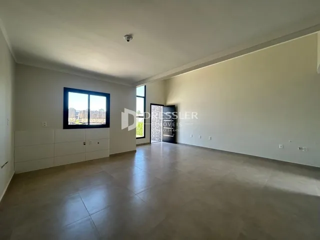 A sala de estar é um ambiente amplo com piso de cerâmica e grande janela.