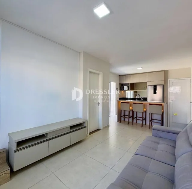 Ambiente interno de uma sala de estar com piso de cerâmica clara.