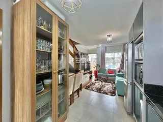 Ambiente interno de uma sala de estar com armários de madeira e móveis modernos.