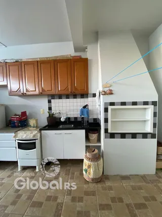 Cozinha com armários de madeira e revestimento de azulejos pretos e brancos.