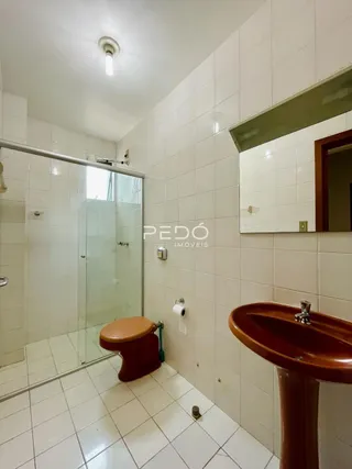 Foto de um banheiro com piso de cerâmica e box de vidro.