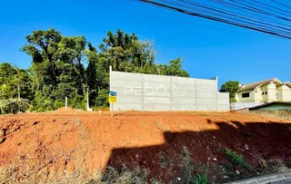 Parede de concreto e terra vermelha em uma propriedade no Brasil.