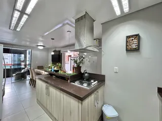 Vista de uma cozinha moderna com armários de madeira e iluminação clara.
