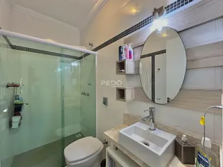 Foto de um banheiro moderno com box de vidro e bancada de mármore.