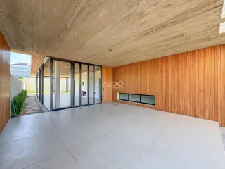 Ambiente interno moderno com teto de concreto e painéis de madeira em uma residência.