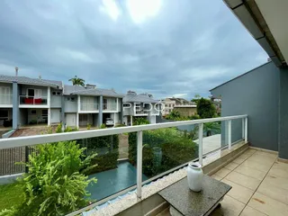 Vista da varanda com grade de vidro e vegetação em Lajeado, Brasil.