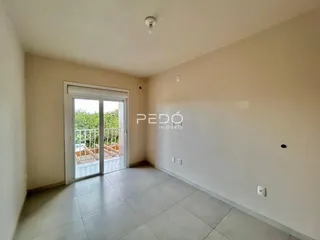 Sala de um imóvel em Lajeado, Brasil, com porta de vidro abrindo para a varanda.