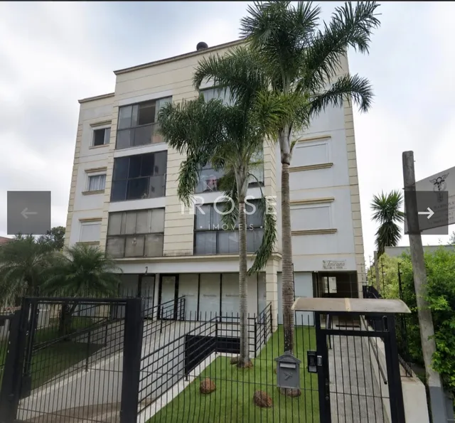 Fachada de um prédio residencial em Lajeado, Brasil, com cerca e paisagismo na frente.