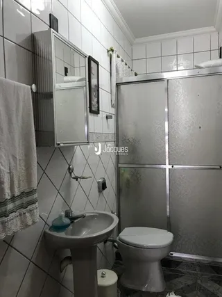 Foto de um banheiro com azulejos brancos e vaso sanitário.