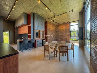Sala de estar e jantar com decoração industrial e parede de tijolos expostos.