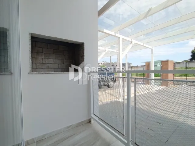 Vista de um canto interno de uma sala com parede texturizada e área externa.