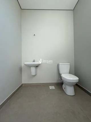 Foto de um banheiro moderno com pia e vaso sanitário brancos.