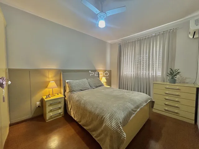 Quarto com cama e móveis de madeira clara em um imóvel no Brasil.