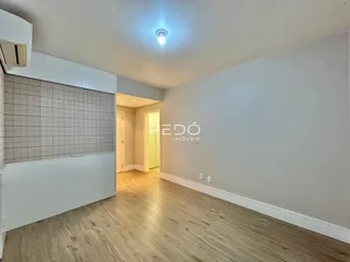 Sala de estar com piso de madeira clara e parede texturizada.