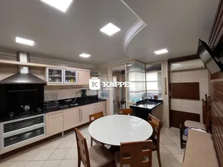 Foto de uma cozinha com armários claros e bancadas escuras.