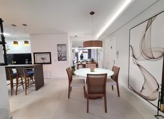 Uma sala de jantar moderna com mesa e cadeiras em um imóvel em Lajeado.