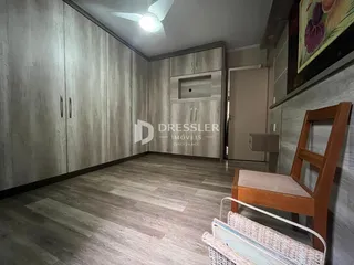 Interior de um quarto com armários de madeira e piso claro.