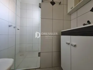 Foto de um banheiro com revestimento cerâmico e box de vidro.