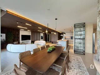 Sala de estar e jantar de uma residência moderna com painéis de madeira.