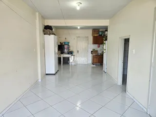 Corredor interno de uma residência com piso de cerâmica branca.
