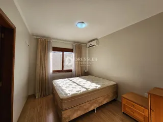 Quarto com cama e piso de madeira na residência.