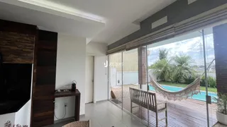 Sala de estar com vista para um quintal com piscina e deck de madeira.
