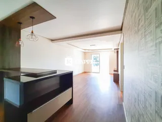 Sala de estar com piso de madeira e móveis escuros.